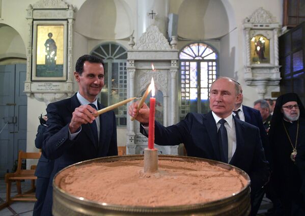 الرئيس فلاديمير بوتين والرئيس بشار الأسد يضيئان الشموع في الكنيسة المريمية‎ في دمشق، 7 يناير 2020 - سبوتنيك عربي