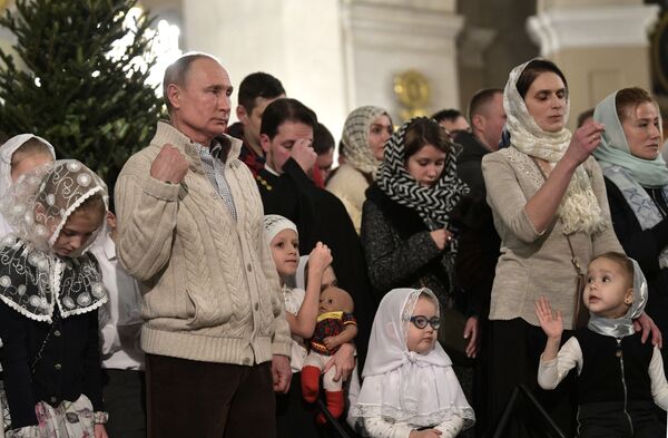 الرئيس فلاديمير بوتين خلال مراسم الاحتفال بعيد الميلاد في كتدرائية التجلي في مدينة سان بطرسبورغ الروسية، 6 يناير 2020 - سبوتنيك عربي