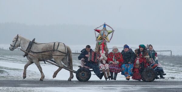 مواطنون يحتفلون بعيد شتوي اسمه كوليادكي، في قرية دوبوفكا، الذي يتزامن مع عيد الميلاد الأرثوذكسي في بيلاروسيا 7 يناير 2020 - سبوتنيك عربي