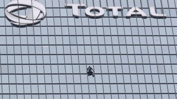 الرجل العنكبوت الفرنسي، ألان روبير، يتسلق برج توتال، في العاصمة الفرنسية باريس، تضامنا مع عمال محتجين على إصلاح نظام معاشات التقاعد، 13 يناير/ كانون الثاني 2020 - سبوتنيك عربي