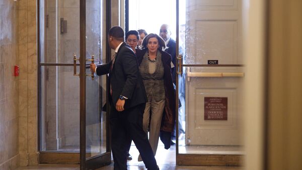 رئيسة مجلس النواب الأمريكي نانسي بيلوسي مع طاقم عملها وهي تسير إلى مكتبها في مبنى الكابيتول الأمريكي في واشنطن - سبوتنيك عربي