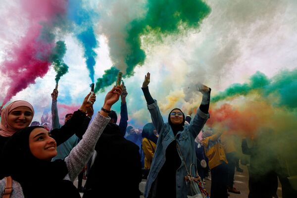 نساء عراقيات يلوحن بشموع دخان ملونة خلال مهرجان الألوان في مدينة النجف، العراق  15 يناير 2020 - سبوتنيك عربي