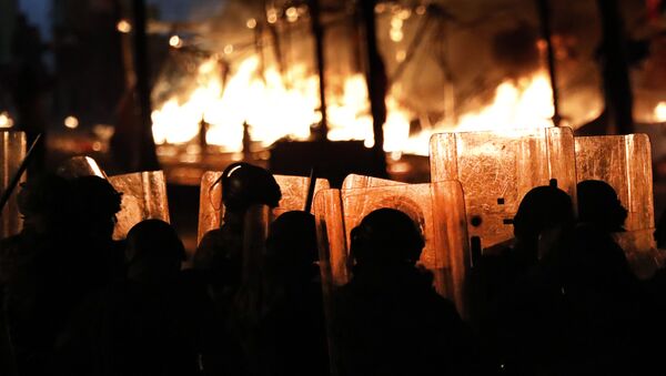 رجال شرطة مكافحة الشغب يشاهدون النيران تتصاعد من خيام المتظاهرين المناهضين للحكومة في بيروت في لبنان - سبوتنيك عربي