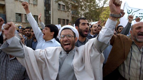 رجل دين إيراني يردد شعارات أثناء احتجاج يندد بتعهد إيران بفتح برنامجها النووي أمام عمليات التفتيش غير المقيدة وتعليق تخصيب اليورانيوم بعد صلاة الجمعة في طهران الجمعة 31 أكتوبر 2003 - سبوتنيك عربي