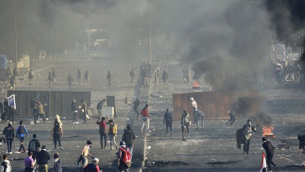 متظاهرون مناهضون للحكومة يشعلون النار ويغلقون الشوارع بينما تستخدم قوات الأمن الغاز المسيل للدموع في وسط بغداد في العراق - سبوتنيك عربي