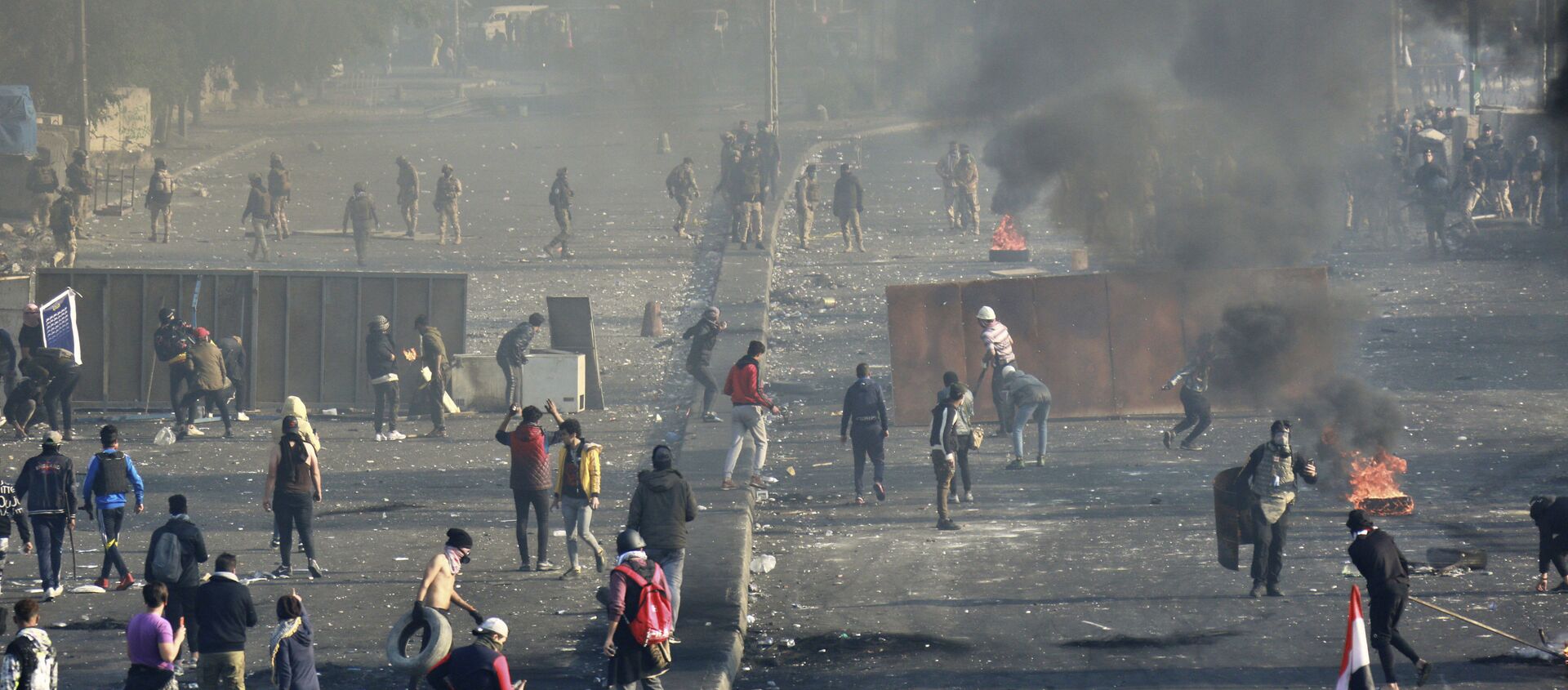 متظاهرون مناهضون للحكومة يشعلون النار ويغلقون الشوارع بينما تستخدم قوات الأمن الغاز المسيل للدموع في وسط بغداد في العراق - سبوتنيك عربي, 1920, 26.05.2021
