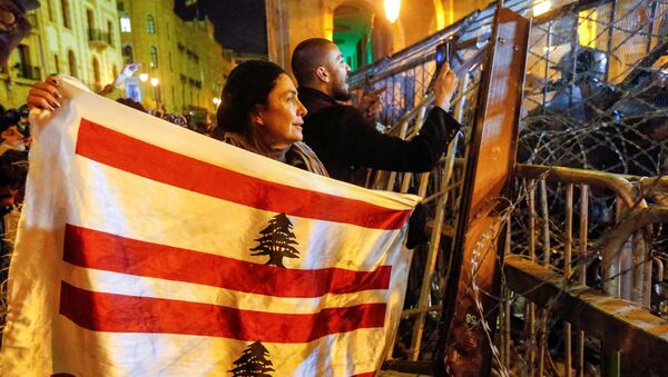 متظاهرة تحمل العلم اللبناني خلال مظاهرة ضد نخبة حاكمة متهمة بتوجيه لبنان نحو الأزمة الاقتصادية في بيروت - سبوتنيك عربي