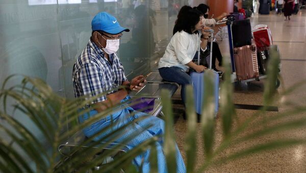 أشخاص يرتدون أقنعة الوجه في قاعة الوصول بمطار يانغون الدولي في يانغون - سبوتنيك عربي