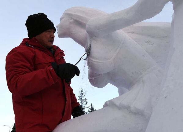 الفائز في الفئة المرشحة الثلج يعمل على منحوتة ثلجية في المهرجان الدولي السنوي الثامن للثلوج والمنحوتات الثلجية في كراسنويارسك الروسية، 17 يناير 2020 - سبوتنيك عربي