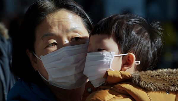 أم وطفلها يرتديان قناع الوجه خوفا من فيروس كرورنا الجديد في كوريا الجنوبية - سبوتنيك عربي