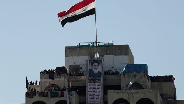 متظاهرون عراقيون يقفون على مبنى شاهق يطلق عليه مبنى المطعم التركي العراقي خلال الاحتجاجات المستمرة المناهضة للحكومة في بغداد - سبوتنيك عربي