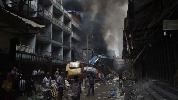 أهالي حي سوق بالوغون في لاغوس يحملون أغراضهم بعد أن تم اطفاء الحريق في المنطقة، نيجيريا 29 يناير 2020 - سبوتنيك عربي