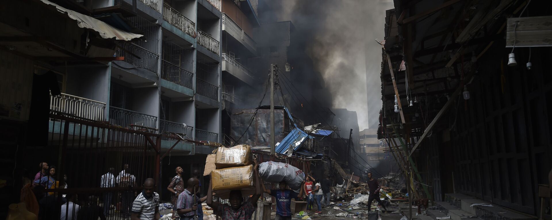 أهالي حي سوق بالوغون في لاغوس يحملون أغراضهم بعد أن تم اطفاء الحريق في المنطقة، نيجيريا 29 يناير 2020 - سبوتنيك عربي, 1920, 10.10.2021