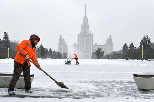 موظفو الخدمة العامة أثناء إزالة الثلوج بالقرب من مبنى جامعة موسكو الحكومية على فوروبيوفي غوري (تلال الدويري) في موسكو، 28 يناير 2020 - سبوتنيك عربي