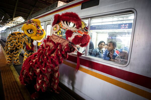 ينظر الركاب عبر نافذة القطار إلى التنانين في محطة غامبير خلال احتفالات السنة القمرية الصينية الجديدة في جاكرتا، إندونيسيا 25 يناير 2020 - سبوتنيك عربي