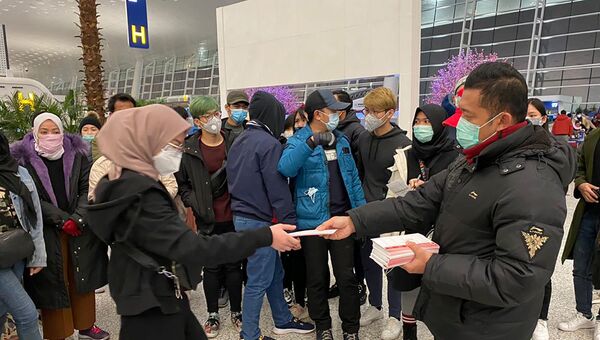 مواطنون إندونيسيون ينتظرون إجلاؤهم من مدينة ووهان الصينية، قبل المغادرة إلى بلادهم في مطار تيانخه الدولي - سبوتنيك عربي