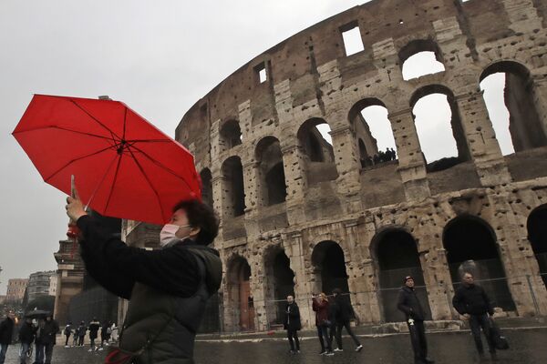سياح يرتدون أقنعة واقية بعد تأكيد حالات الإصابة بفيروس كورونا في إيطاليا، يلتقطون صورة سيلفي على خلفية  كولوسيوم في روما، 1 فبراير 2020 - سبوتنيك عربي