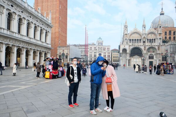 سياح صينيون يرتدون أقنعة واقية بعد تأكيد حالات الإصابة بفيروس كورونا في إيطاليا، يلتقطون صورا في ساحة القديس مرقس (سان ماركوس)، 31 يناير 2020 - سبوتنيك عربي
