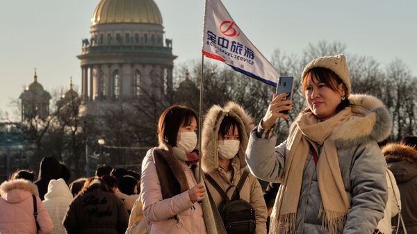 سياح صينيون يرتدون أقنعة واقية، يلتقطون صورا في سان بطرسبورغ، 23 يناير 2020 - سبوتنيك عربي