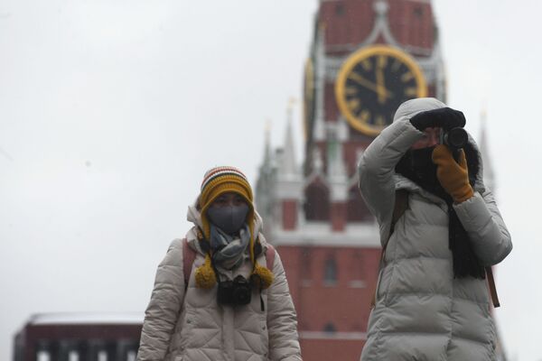 أشخاص يرتدون أقنعة واقية بعد تأكيد حالات الإصابة بفيروس كورونا في روسيا، يلتقطون صورا في موسكو، 28 يناير 2020 - سبوتنيك عربي