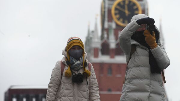 أشخاص يرتدون أقنعة واقية بعد تأكيد حالات الإصابة بفيروس كورونا في روسيا، يلتقطون صورا في موسكو، 28 يناير 2020 - سبوتنيك عربي