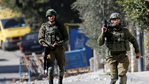 جندي إسرائيلي يركض أثناء غارة في بيت جالا بالضفة الغربية التي تحتلها إسرائيل - سبوتنيك عربي