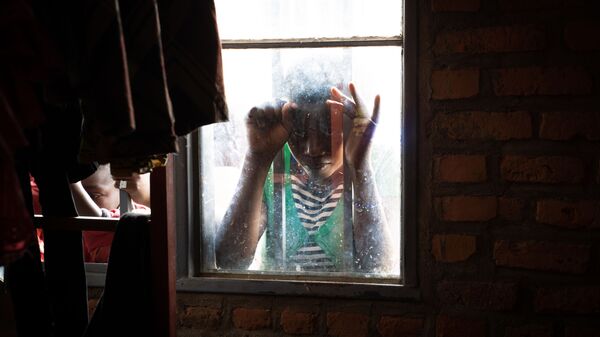 فتاة تنظر عبر نافذة مركز للمهاجرين في نيروشيشي، رواندا 31 يناير 2020 - سبوتنيك عربي
