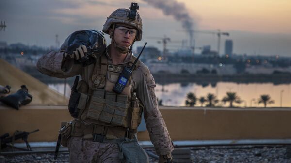 أحد أفراد مشاة البحرية الأمريكية مع الكتيبة الثانية المارينز السابع الذي يعد جزءًا من قوة الرد السريع يحمل كيسًا من الرمل أثناء تعزيز مجمع السفارة الأمريكية في بغداد في العراق - سبوتنيك عربي