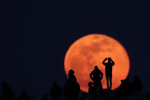 أشخاص يراقبون ارتفاع القمر الكامل من الموقع الأثري أكروبول في أثينا، اليونان 9 فبراير 2020 - سبوتنيك عربي