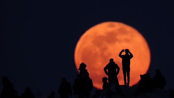 أشخاص يراقبون ارتفاع القمر الكامل من الموقع الأثري أكروبول في أثينا، اليونان 9 فبراير 2020 - سبوتنيك عربي