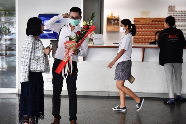 زوجان يرتديان أقنعة واقية في مركز لتسجيل الحالات المدنية في يوم فالنتاين (عيد الحب) في بانكوك، تايلاند 14 فبراير 2020 - سبوتنيك عربي