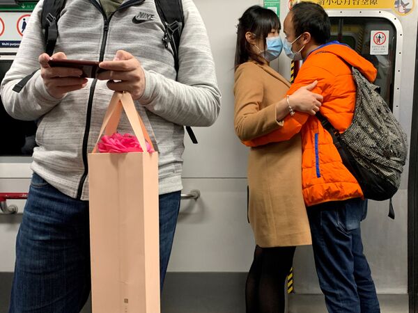 شخصان يرتديان أقنعة واقية في مترو في هونغ كونغ، الصين 14 فبراير 2020 - سبوتنيك عربي