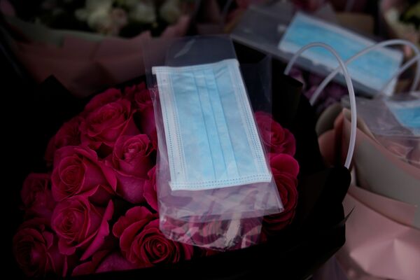 قناع واقي على باقة زهور في متجر لبيع الزهور بمناسبة يوم فالنتاين (عيد الحب) في شنغهاي، الصين 14 فبراير 2020 - سبوتنيك عربي
