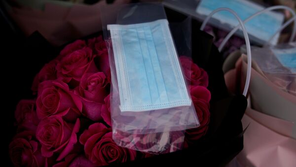 قناع واقي على باقة زهور في متجر لبيع الزهور بمناسبة يوم فالنتاين (عيد الحب) في شنغهاي، الصين 14 فبراير 2020 - سبوتنيك عربي