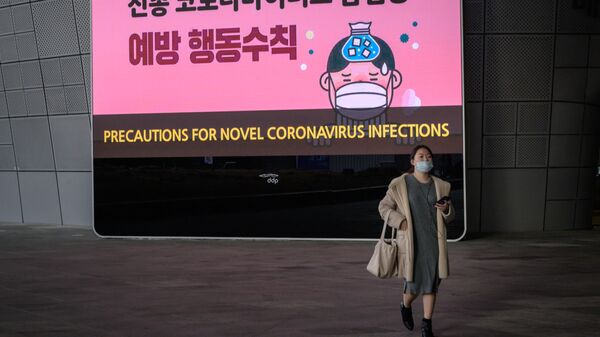 امرأة ترتدي قناعًا أمام شاشة تعرض تدابير وقائية ضد فيروس كورونا الجديد - كوريا الجنوبية - سبوتنيك عربي