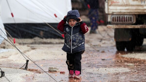 طفلة سورية مهجرة فرت من جنوب إدلب تمشي تحت المطر في عفرين - سبوتنيك عربي