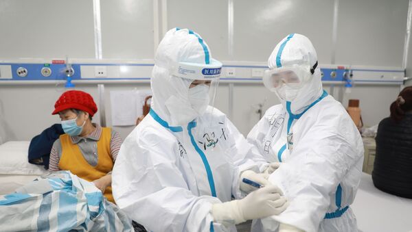 طاقم طبي يعتني بمريض صاب بفيروس كورونا في إقليم هوبي الصيني - سبوتنيك عربي