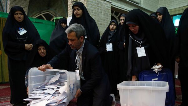 موظفو الاقتراع يفرغون صناديق الاقتراع الكاملة بعد انتهاء فترة التصويت في الانتخابات البرلمانية في طهران - سبوتنيك عربي