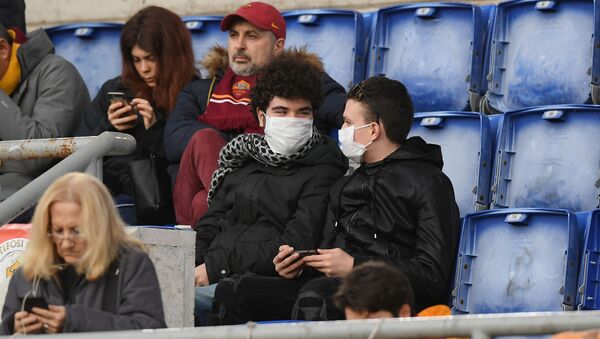 مواطنون إيطاليون يرتدون كمامات واقية من فيروس كورونا خلال إحدى مباريات الدوري الإيطالي الكالتشيو - سبوتنيك عربي