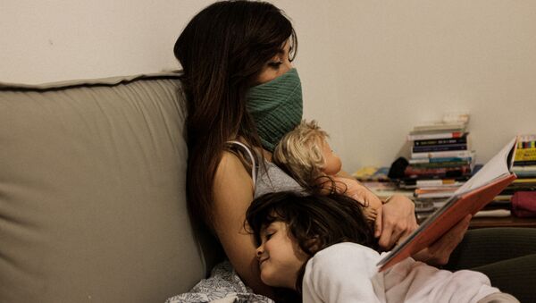 أم وابنتها يجلسون على أريكة في منزل داخل أحد المناطق المصابة بفيروس كورونا - سبوتنيك عربي