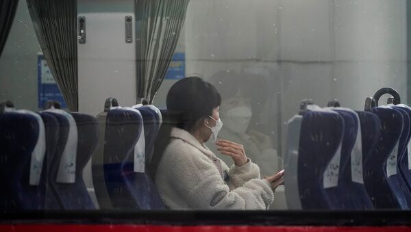 امرأة ترتدي كمامة واقية من فيرووس كورونا تجلس داخل قطار في محطة سكة حديد سيئول فبراير / شباط 2020 - سبوتنيك عربي