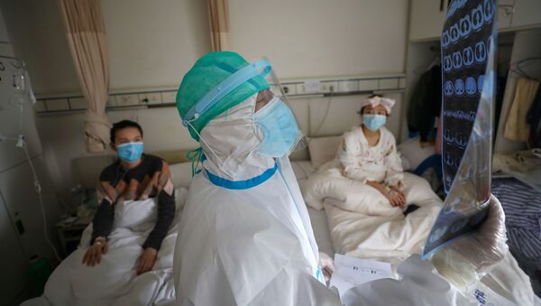طبيب يتفقد الآشعة المقطعية لمرضى بفيروس كورونا في مدينة ووهان الصينية - سبوتنيك عربي