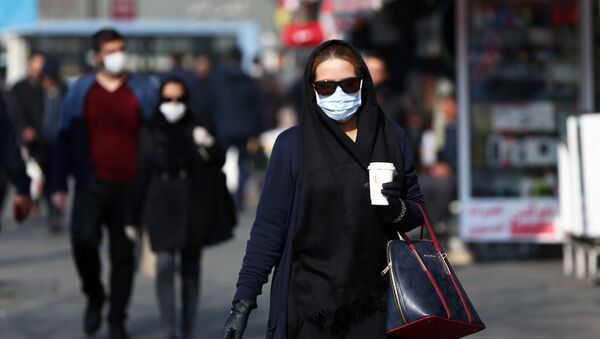 امرأة إيرانية ترتدي قناعًا وقائيًا لمنع الإصابة بفيروس كورونا في الشارع في طهران - سبوتنيك عربي
