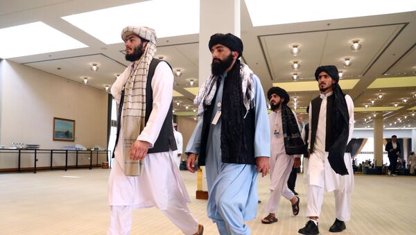 أعضاء وفد طالبان الأفغاني يمشون قبل توقيع اتفاق بينهم وبين المسؤولين الأمريكيين في الدوحة - سبوتنيك عربي