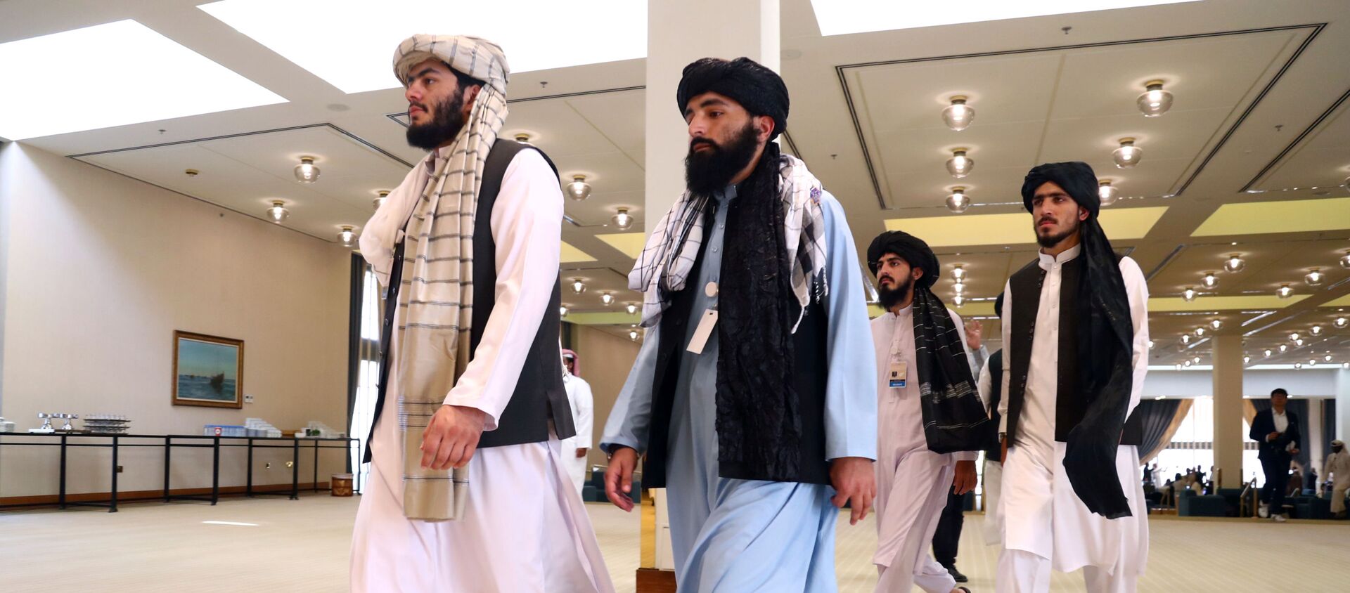 أعضاء وفد طالبان الأفغاني يمشون قبل توقيع اتفاق بينهم وبين المسؤولين الأمريكيين في الدوحة - سبوتنيك عربي, 1920, 17.07.2021