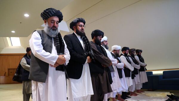 يصلي أعضاء وفد طالبان قبل توقيع الاتفاق بينهم وبين المسؤولين الأمريكيين في الدوحة - سبوتنيك عربي