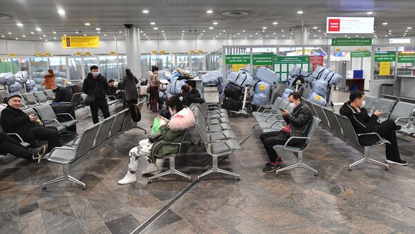 مسافرون يرتدون الكمامات خوفا من كورونا - سبوتنيك عربي