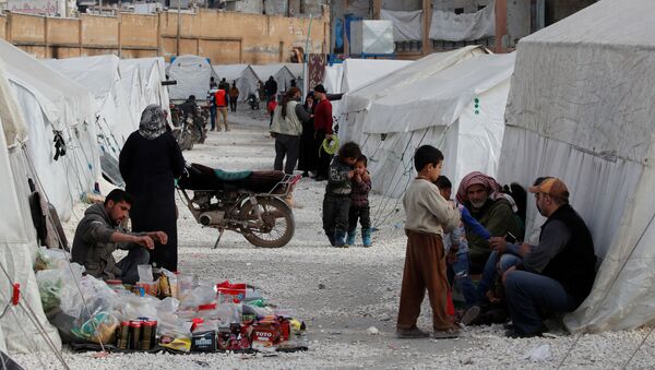 سوريون نازحون داخلياً في معسكر للنازحين في ملعب رياضي حيث توضع الخيام في إدلب - سبوتنيك عربي