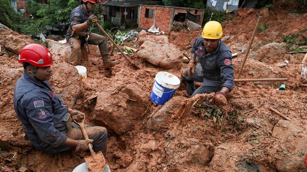 رجال الانقاذ يبحثون عن ضحايا الانهيار الأرضي الناجم عن الأمطار الغزيرة في مدينة غوارويا الساحلية في البرازيل، 3 مارس 2020 - سبوتنيك عربي