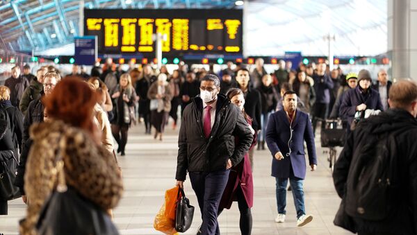 رجل يرتدي قناعا للوجه في محطة واترلو في لندن - سبوتنيك عربي